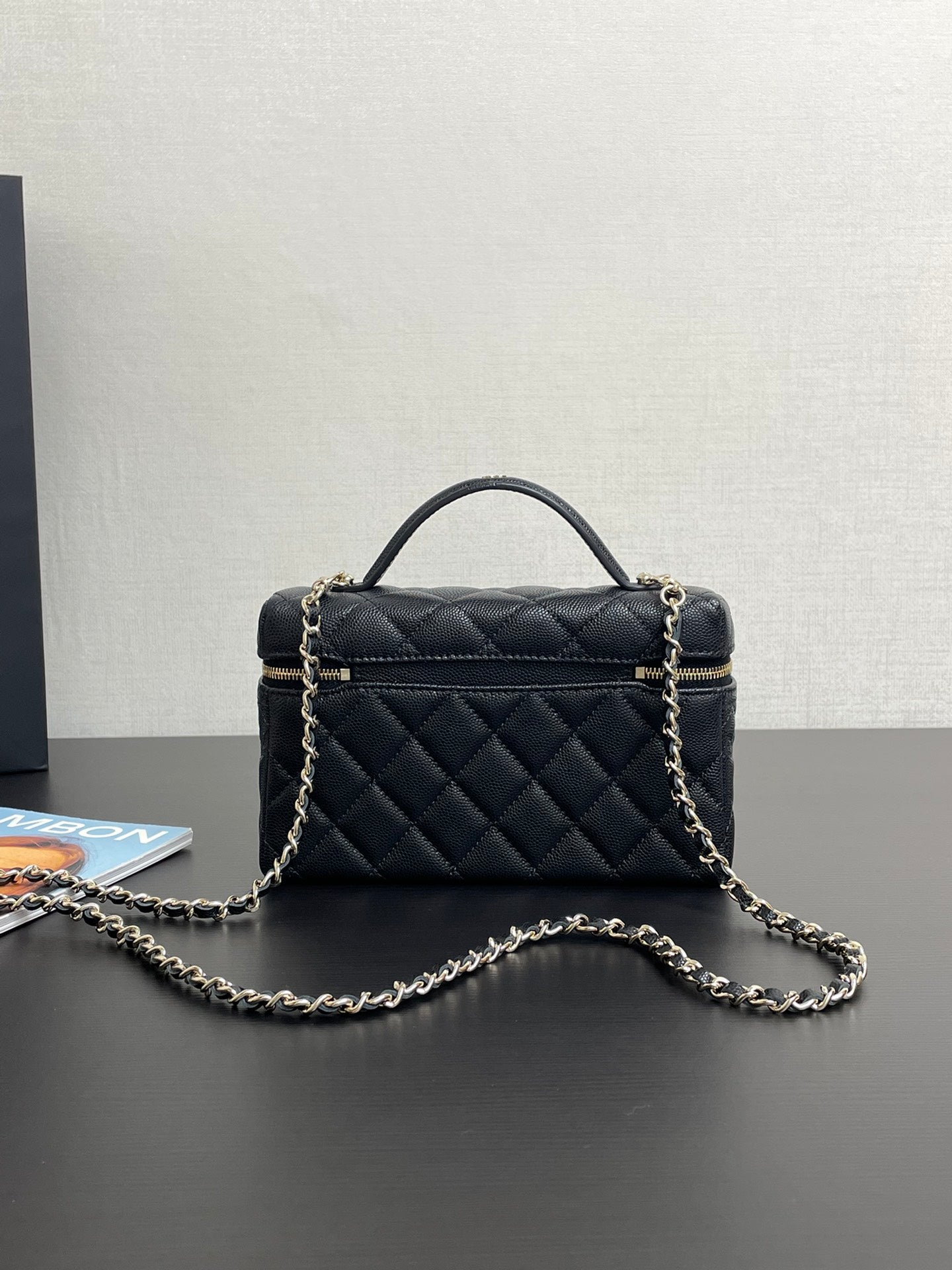 Chanel quilted mini bag with top handle, gold-tone logo, and front zipper detail