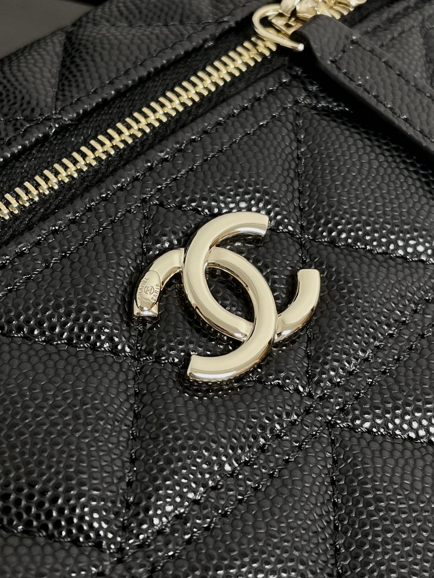 Chanel bag front close-up with gold-tone double C logo and textured quilted leather