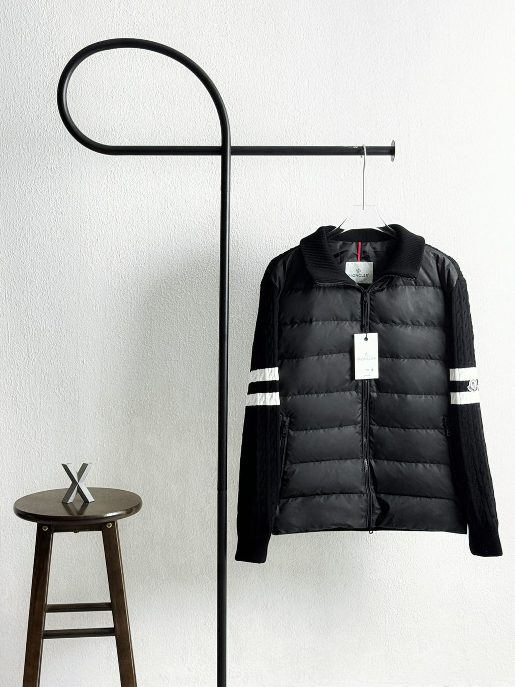Black quilted puffer jacket with zip front and striped sleeve cuffs