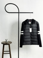 Black quilted puffer jacket with zip front and striped sleeve cuffs