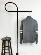 Gray quilted puffer jacket with ribbed knit texture and striped sleeve bands