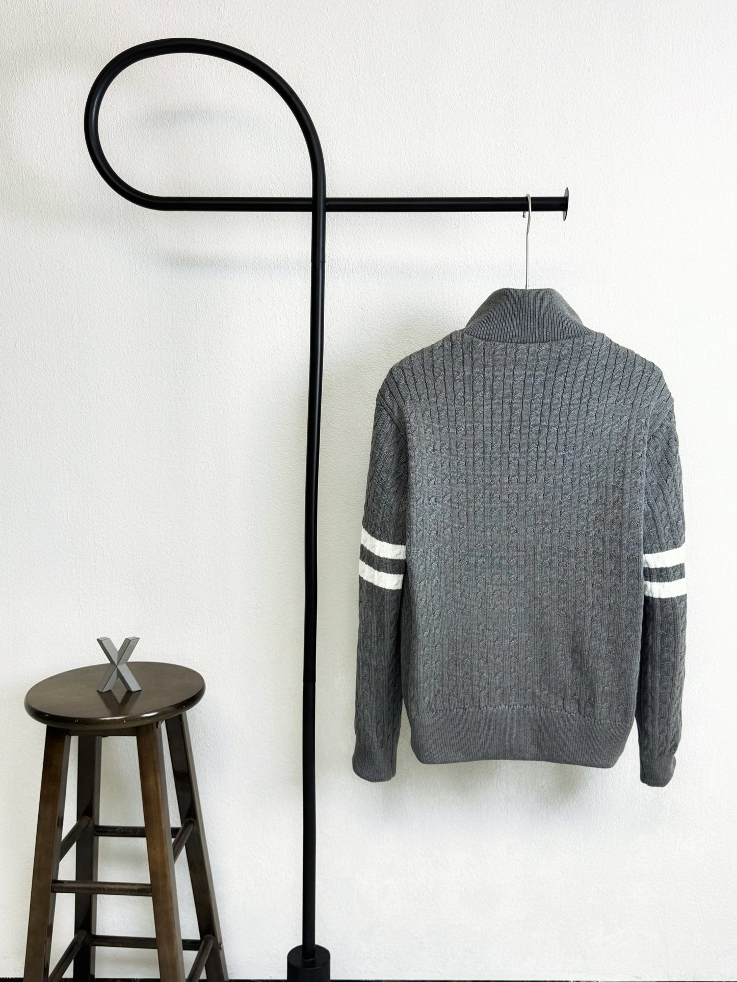 Gray quilted puffer jacket with ribbed knit texture and striped sleeve bands