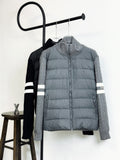 Light gray quilted puffer jacket with zip front and striped sleeve cuffs