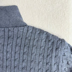 Cable-knit sleeve on a blue puffer jacket with ribbed cuff and knit texture