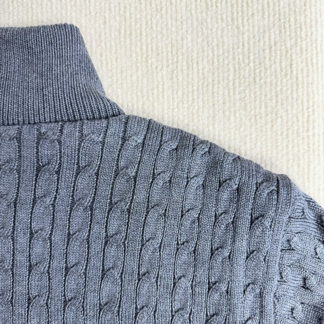 Cable-knit sleeve on a blue puffer jacket with ribbed cuff and knit texture
