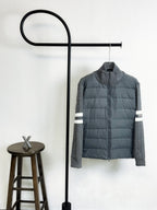 Gray quilted puffer jacket with zip front and white striped sleeve cuffs