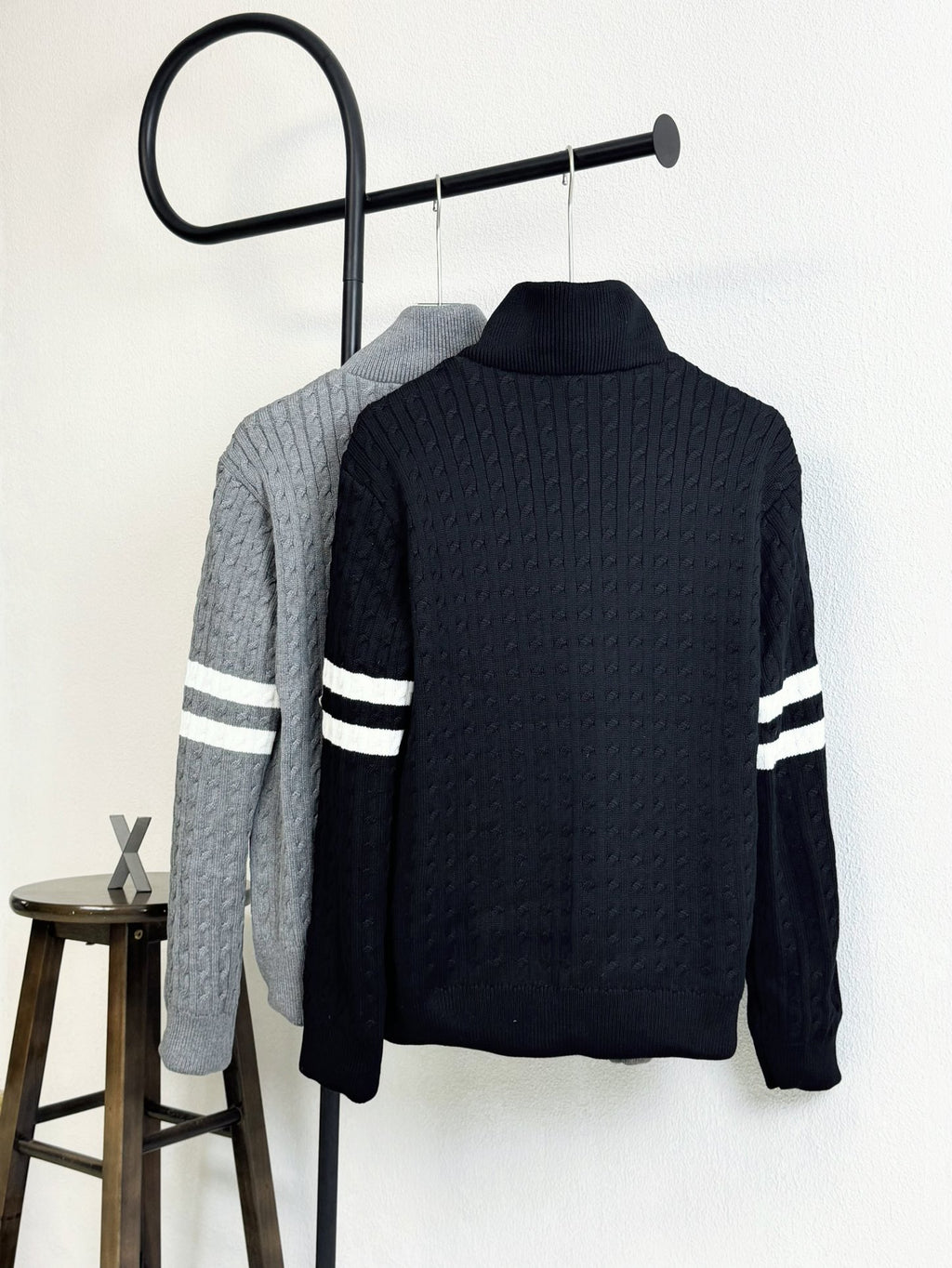 Dark navy quilted puffer jacket with high knit collar and striped sleeve bands