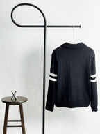 Black quilted puffer jacket with ribbed knit back and striped sleeve bands