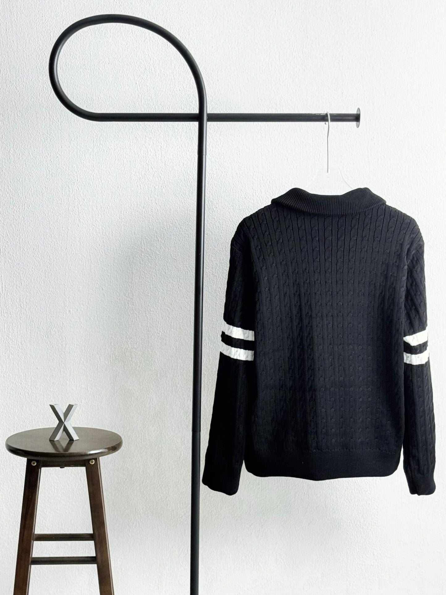 Black quilted puffer jacket with ribbed knit back and striped sleeve bands