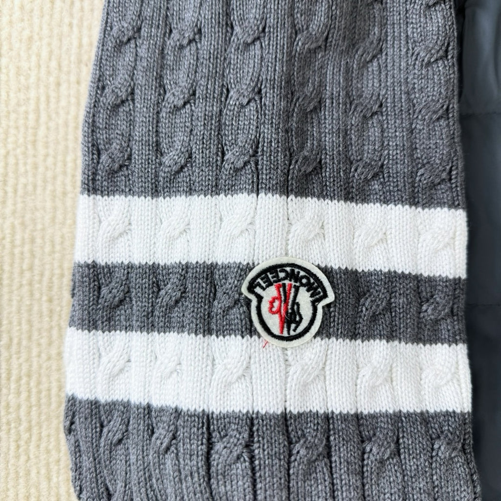 Striped ribbed knit cuff with round logo patch on a long puffer jacket