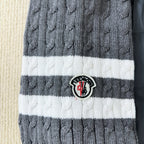 Striped ribbed knit cuff with round logo patch on a long puffer jacket