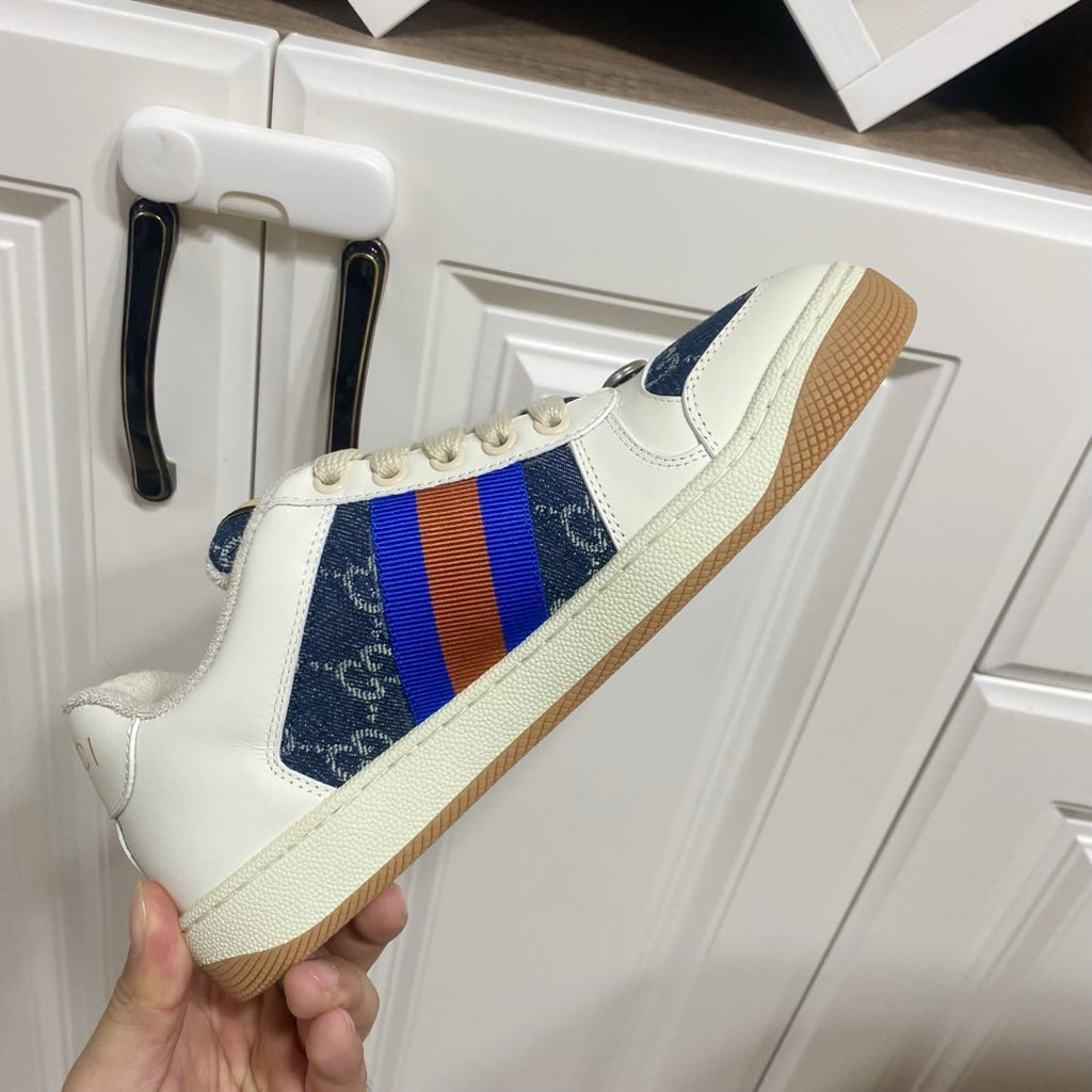 Gucci unisex sneaker side view, white upper with blue patterned panel and multicolor web stripe