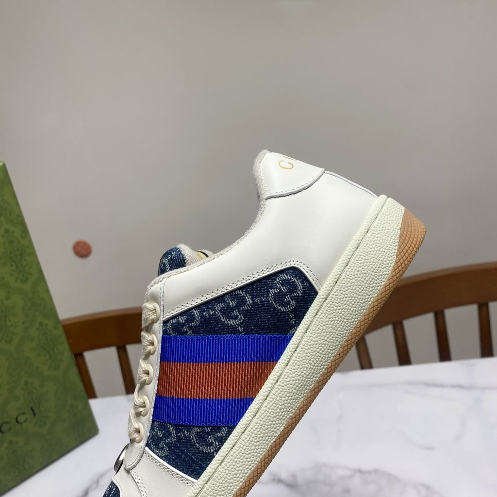 Gucci unisex sneaker front quarter view, white leather with blue patterned heel and rainbow web stripe