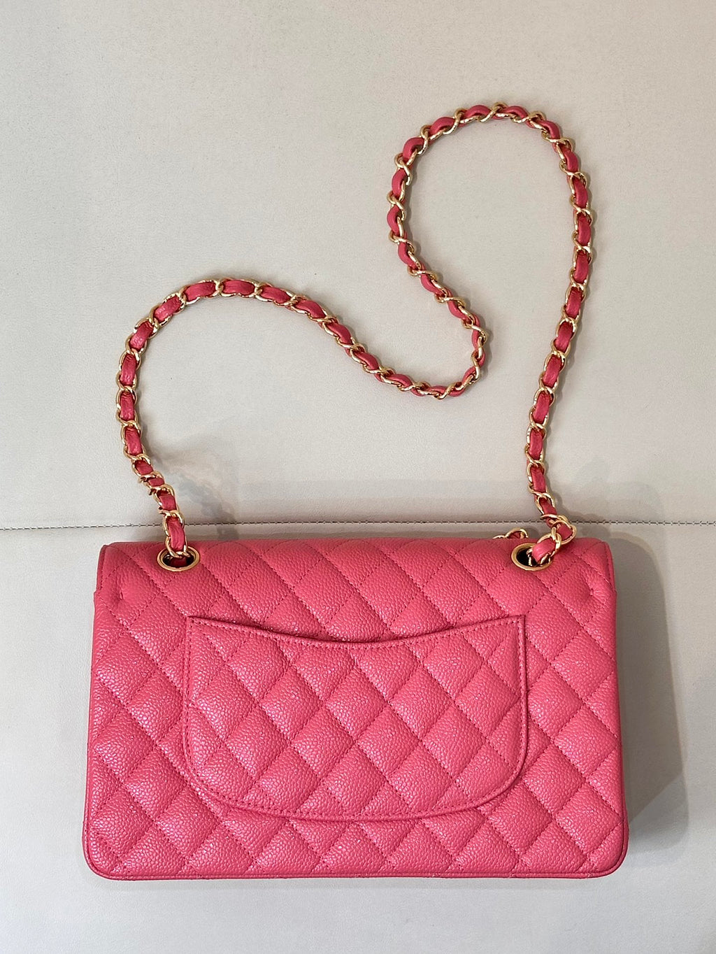 Fuchsia mini shoulder bag with quilted pattern, chain strap, and gold clasp