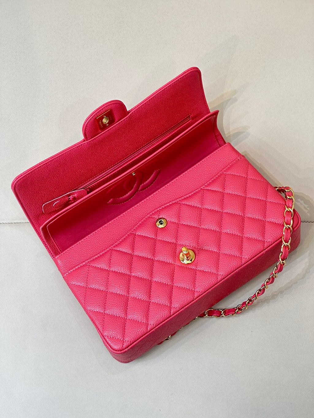 Fuchsia quilted leather handbag with flap closure, gold turn-lock, and chain strap