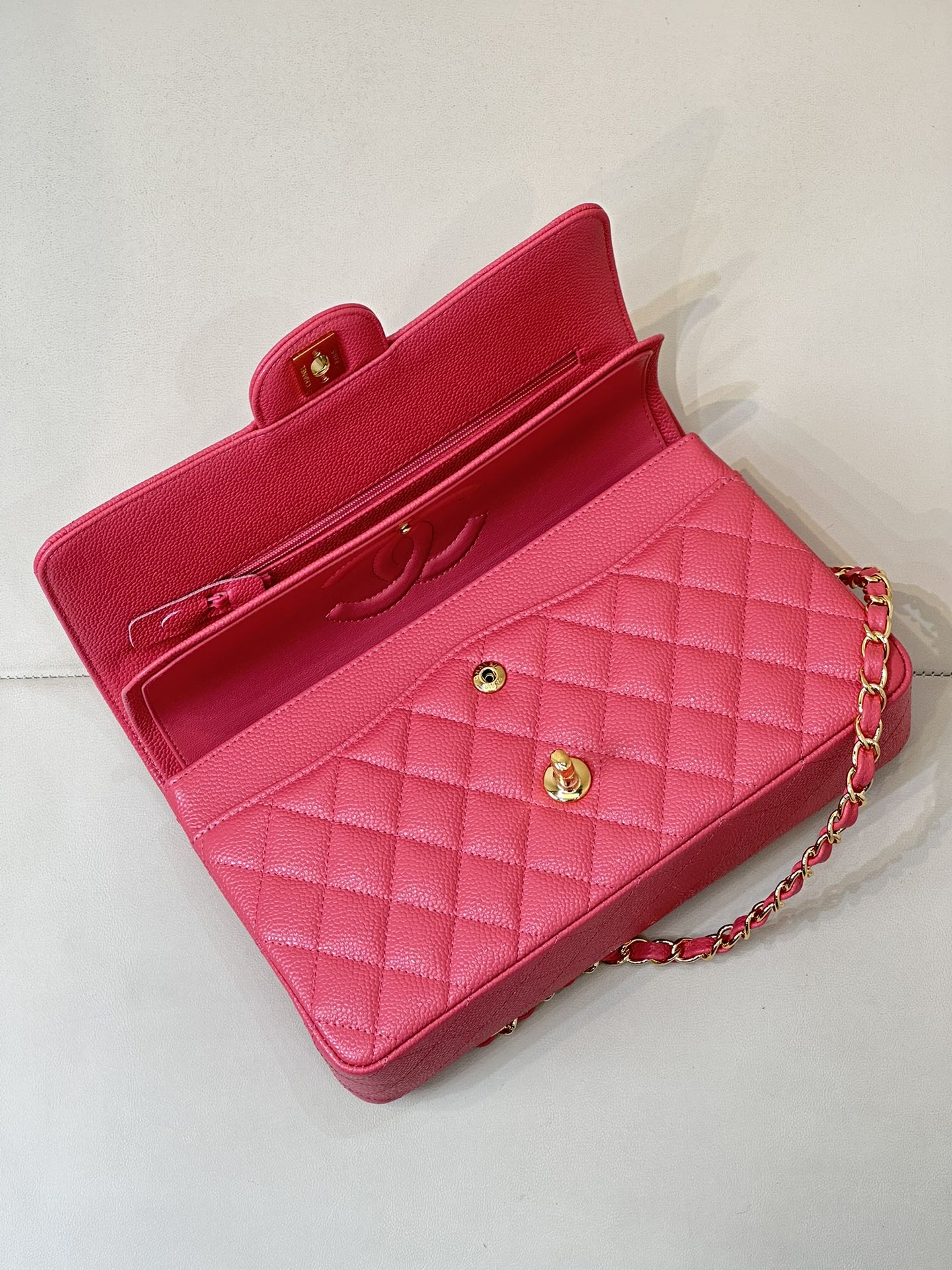 Fuchsia quilted leather handbag with flap closure, gold turn-lock, and chain strap