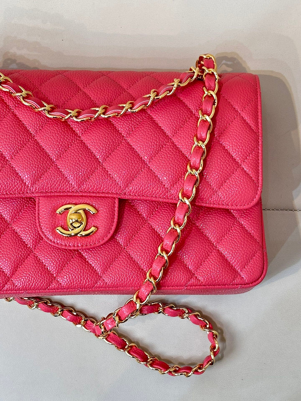Fuchsia quilted leather flap shoulder bag close-up of gold Chanel logo and chain
