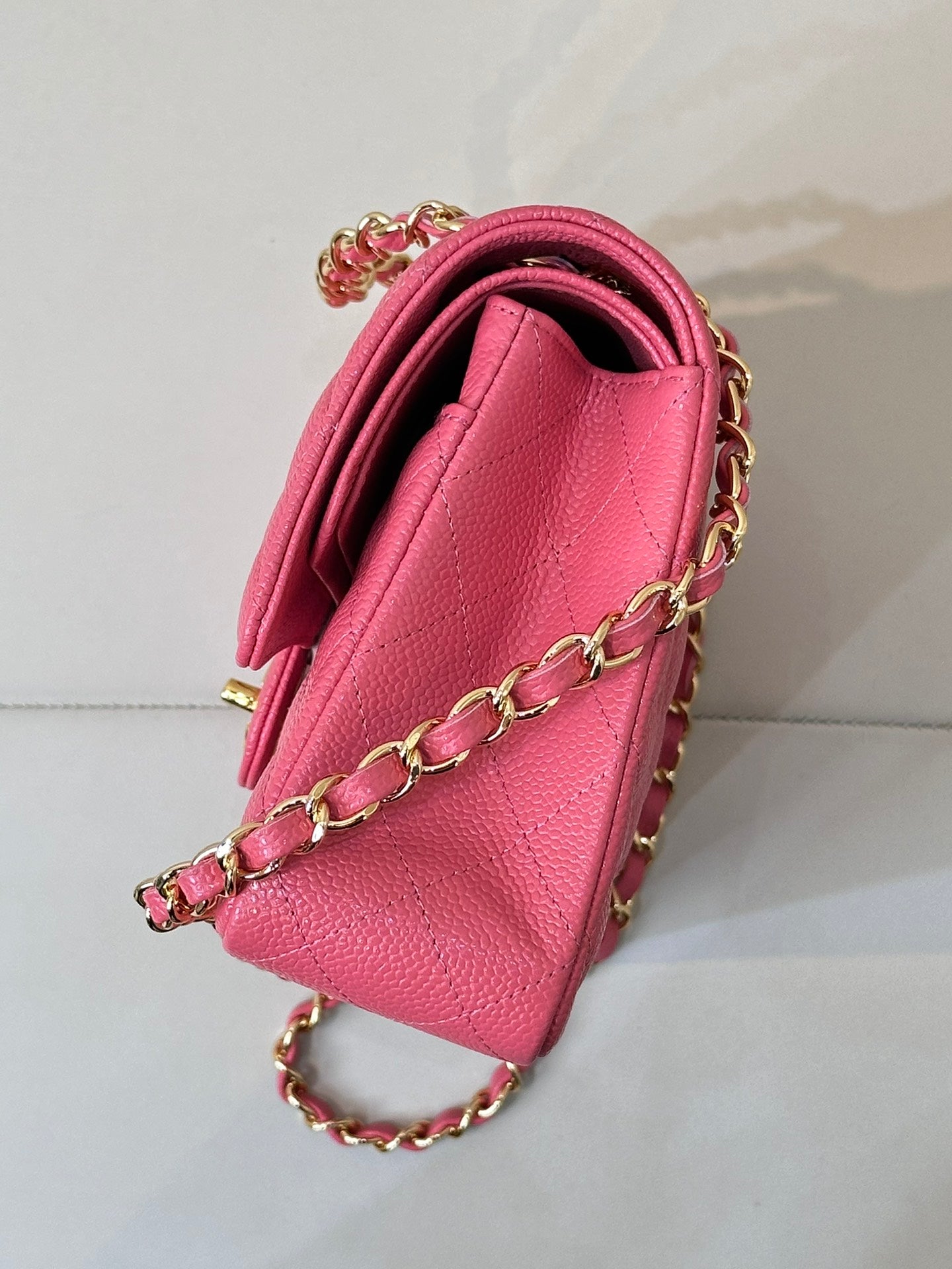 Fuchsia leather handbag with quilted texture and gold chain strap