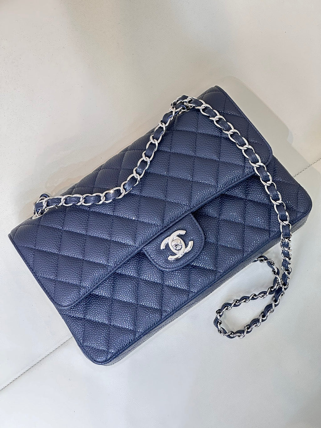 Quilted leather flap shoulder bag with chain strap, front view, dark navy blue.