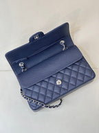 Quilted leather flap shoulder bag with chain strap, front view showing flap interior.