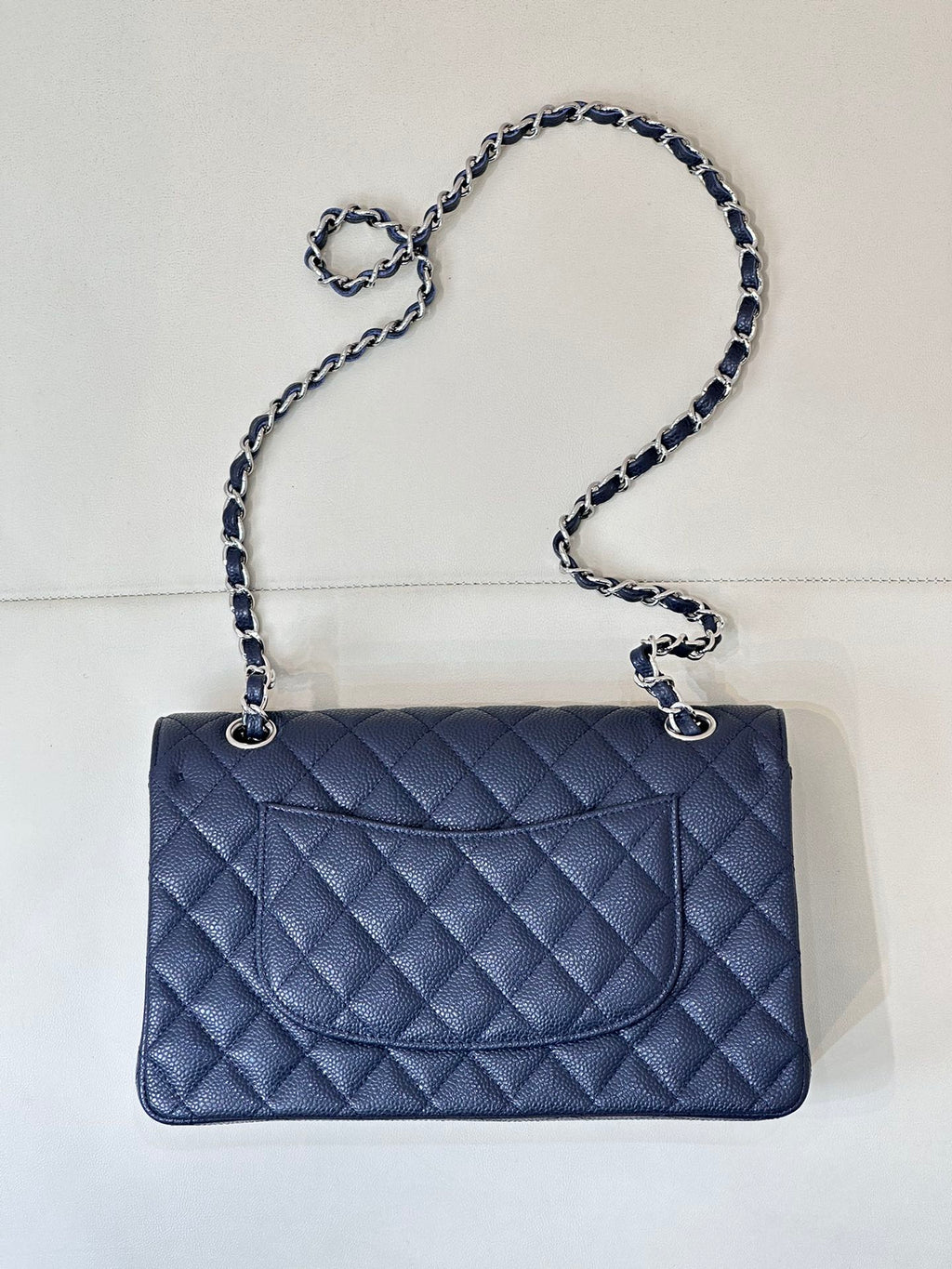 Quilted leather flap shoulder bag with chain strap, straight-on view, dark navy blue.