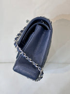 Navy quilted leather shoulder bag with chain strap, side view and top handle.