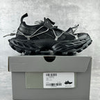Balenciaga unisex sneakers on box, black upper with silver laces and raised trail sole