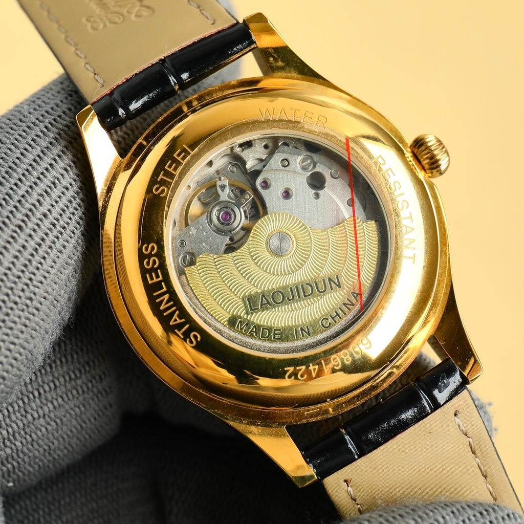 Rolex wrist watch caseback: visible movement, gold-tone case, black strap