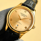 Rolex wrist watch: gold-tone case, light dial, black leather strap