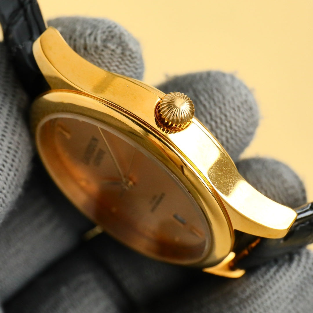 Rolex wrist watch: angled view of gold-tone caseback and black leather strap