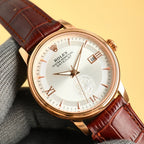 Gold-tone Datejust wristwatch with white dial and Roman numerals, brown leather strap