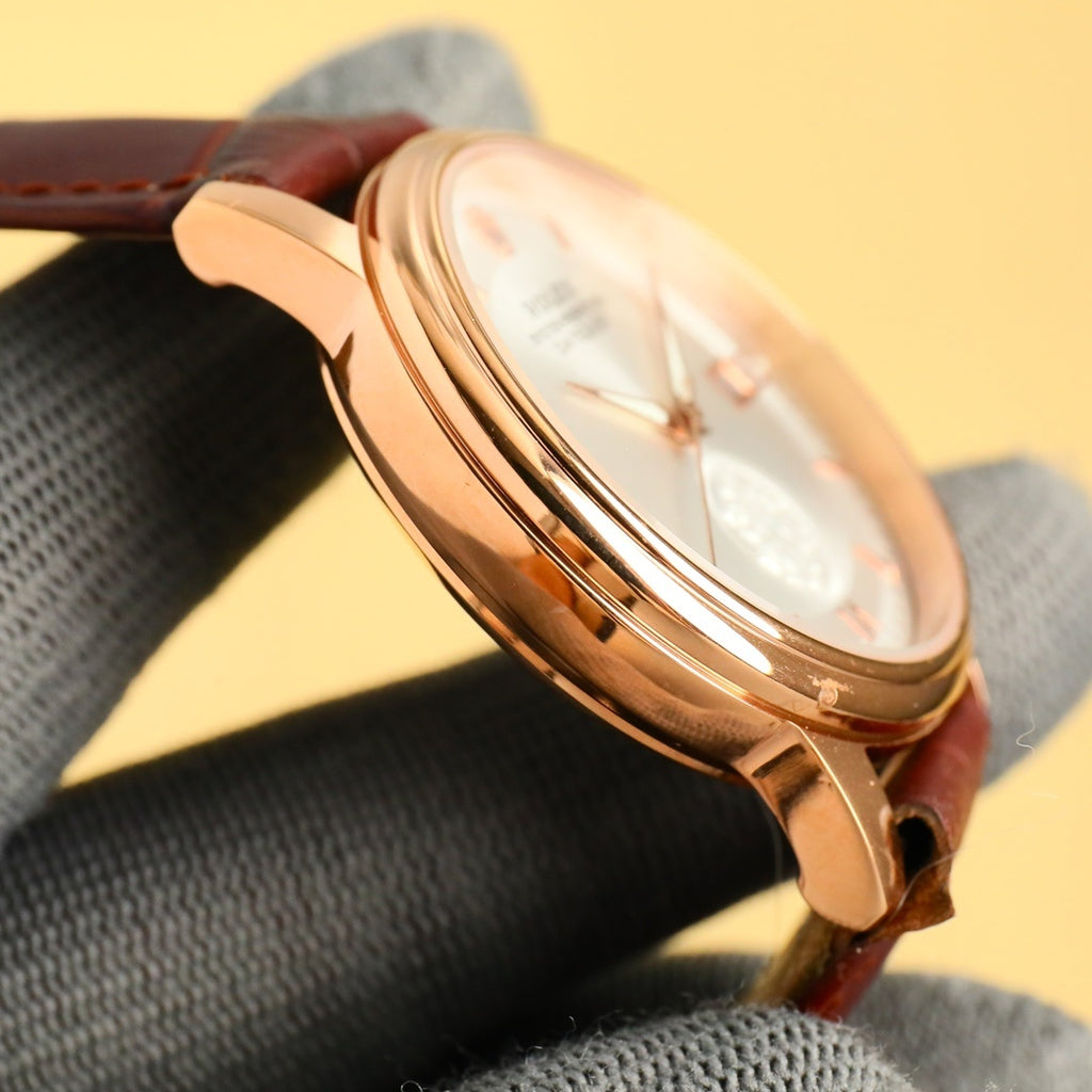 Gold-tone Datejust wristwatch side profile with crown and brown leather strap