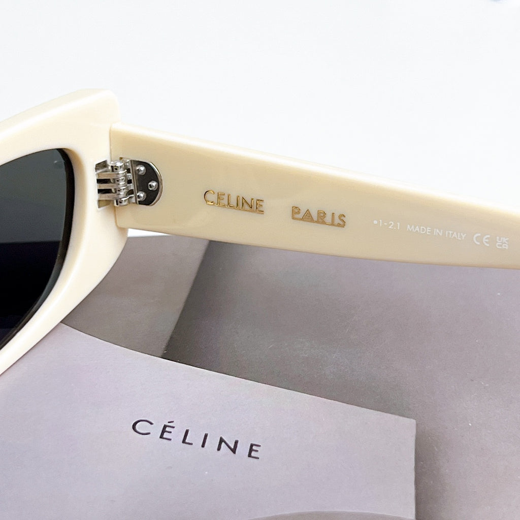 Celine sunglasses, cream temple with logo detail, dark lens visible from side.