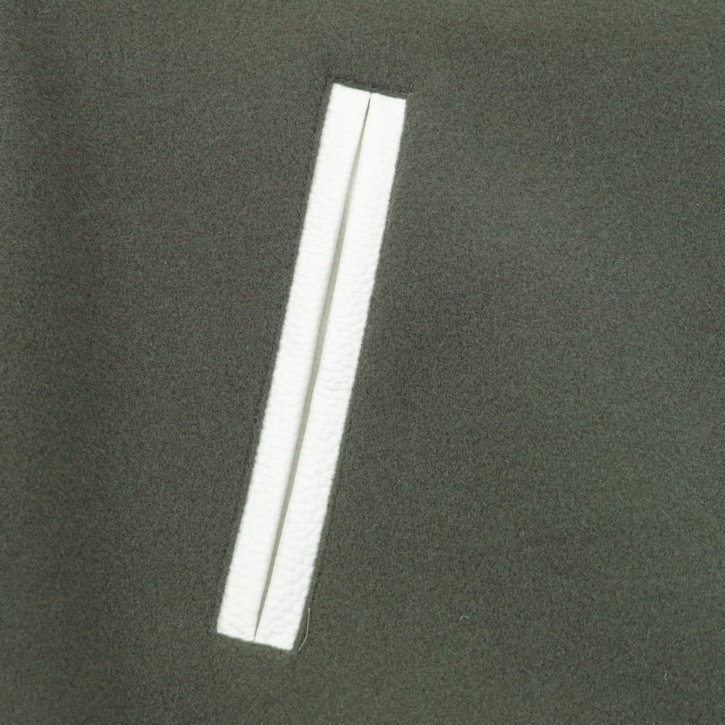 Dark green jacket with white vertical stripe pocket detail
