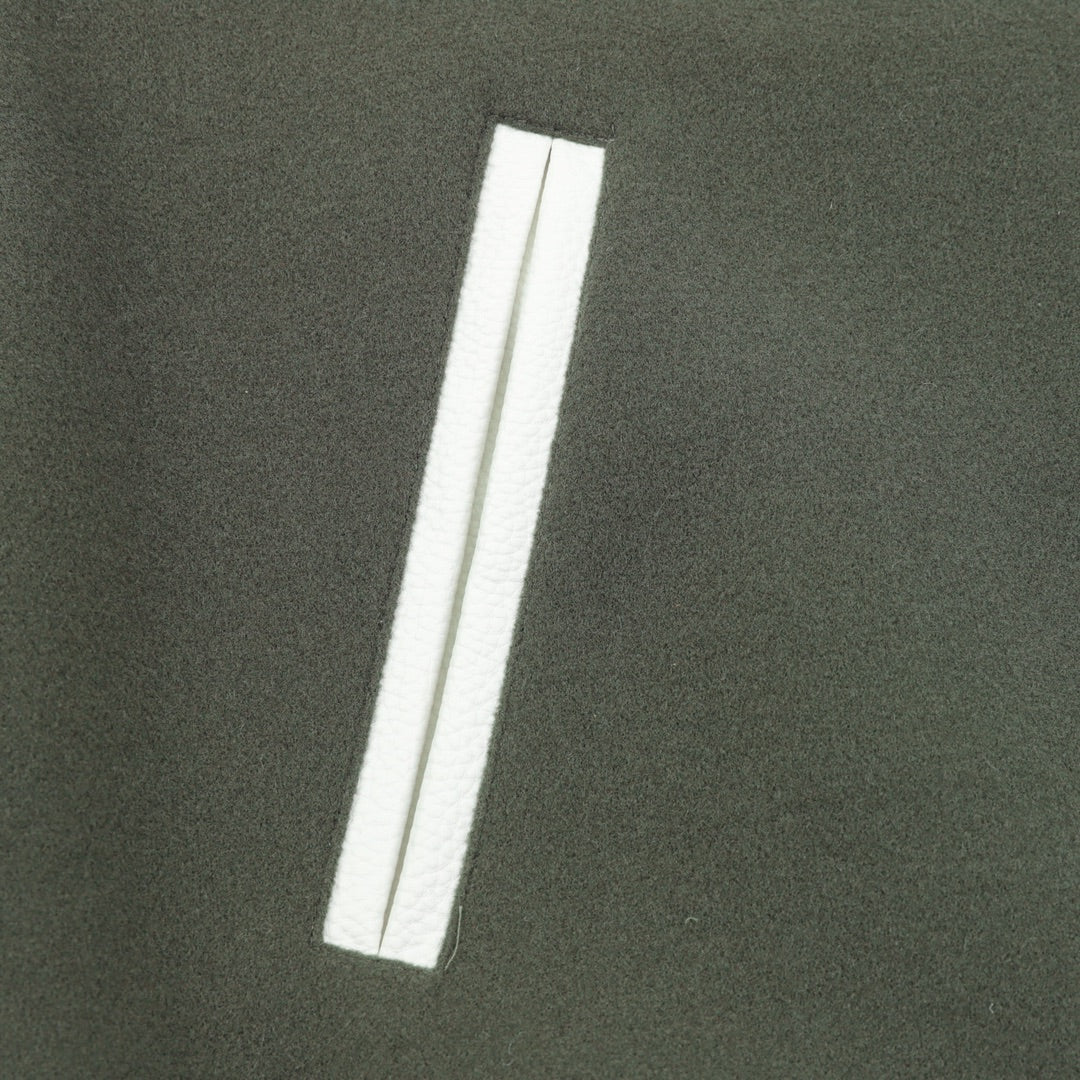 Dark green jacket with white vertical stripe pocket detail