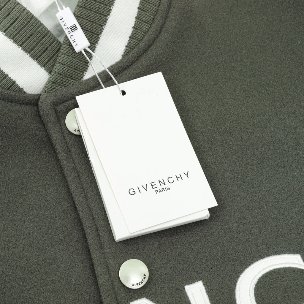 Dark green jacket with ribbed collar, snap buttons, and attached tag
