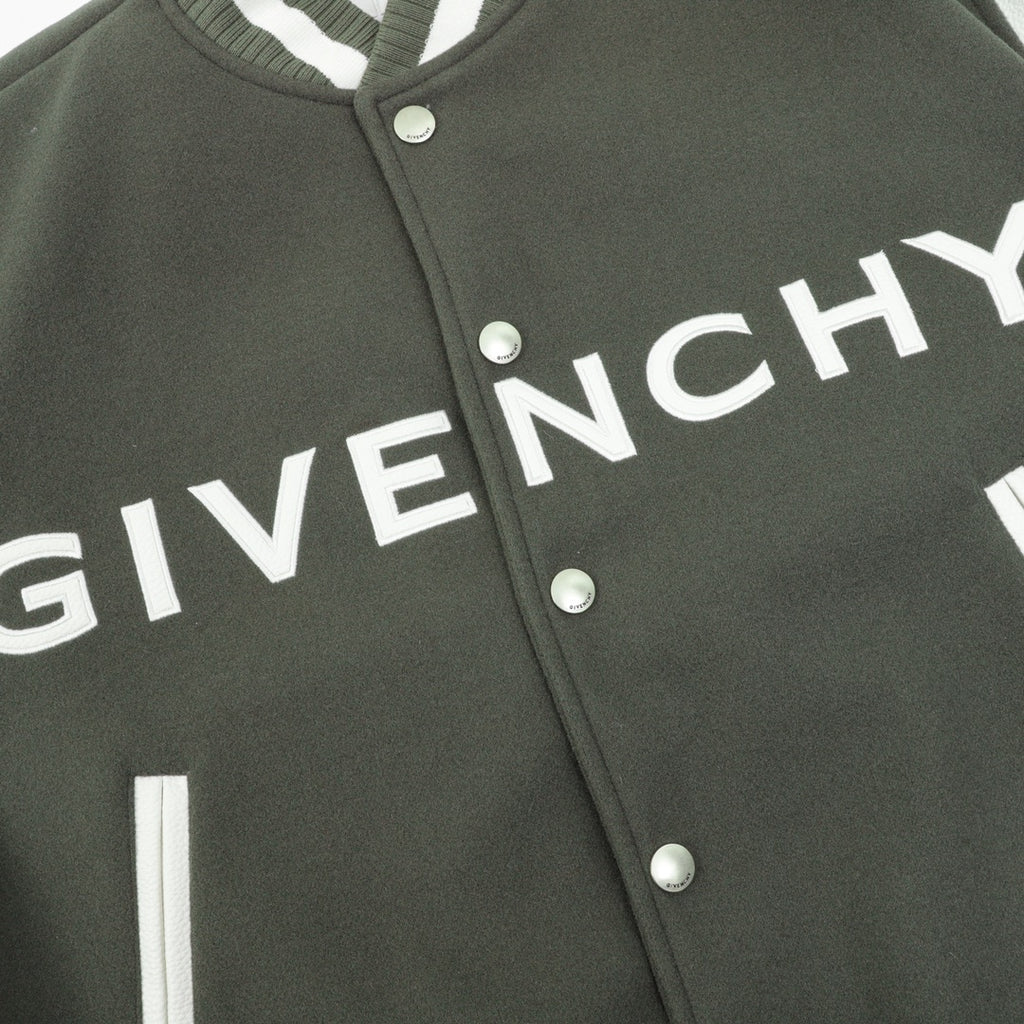 Dark green jacket front with white Givenchy lettering and snap buttons