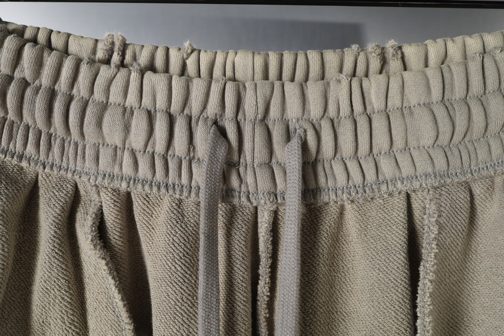 Beige elastic waistband pants with front drawstring ties.