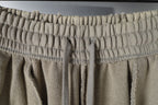 Beige elastic waistband pants with front drawstring ties.