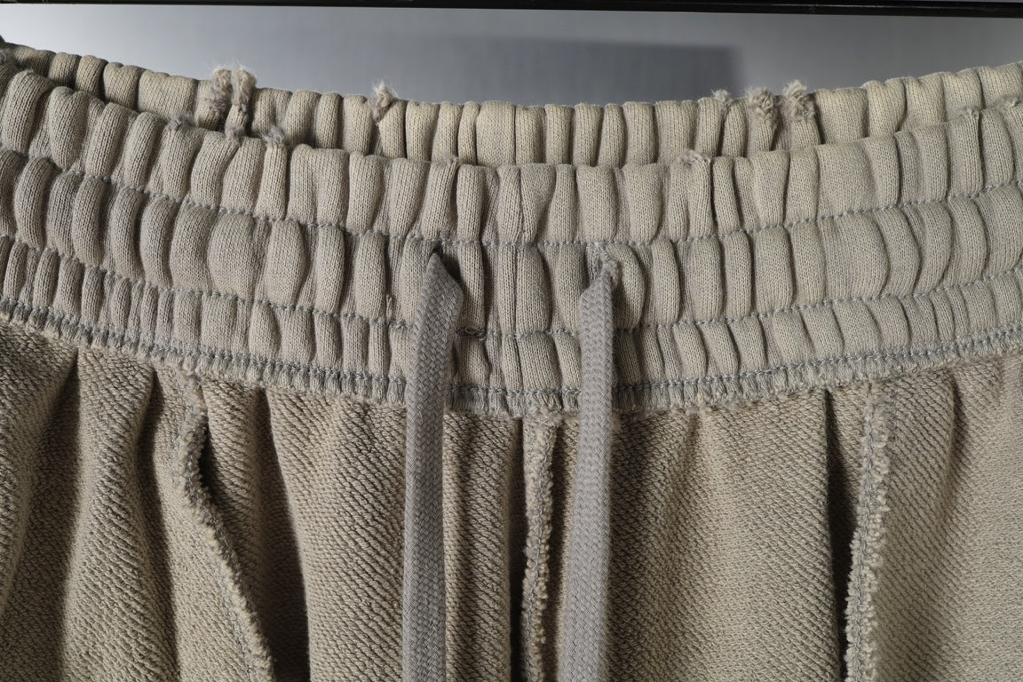 Beige pants with elastic waistband and gathered fabric at the top