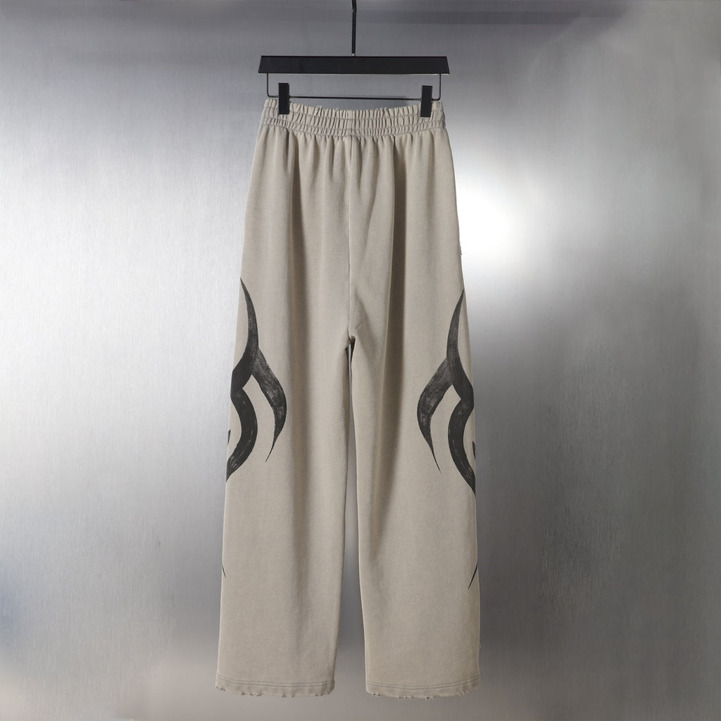 Beige wide-leg pants with black flame graphic detail on the outer legs