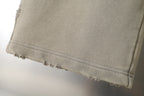 Beige pants hem with stitched edge and slight fraying at the bottom.