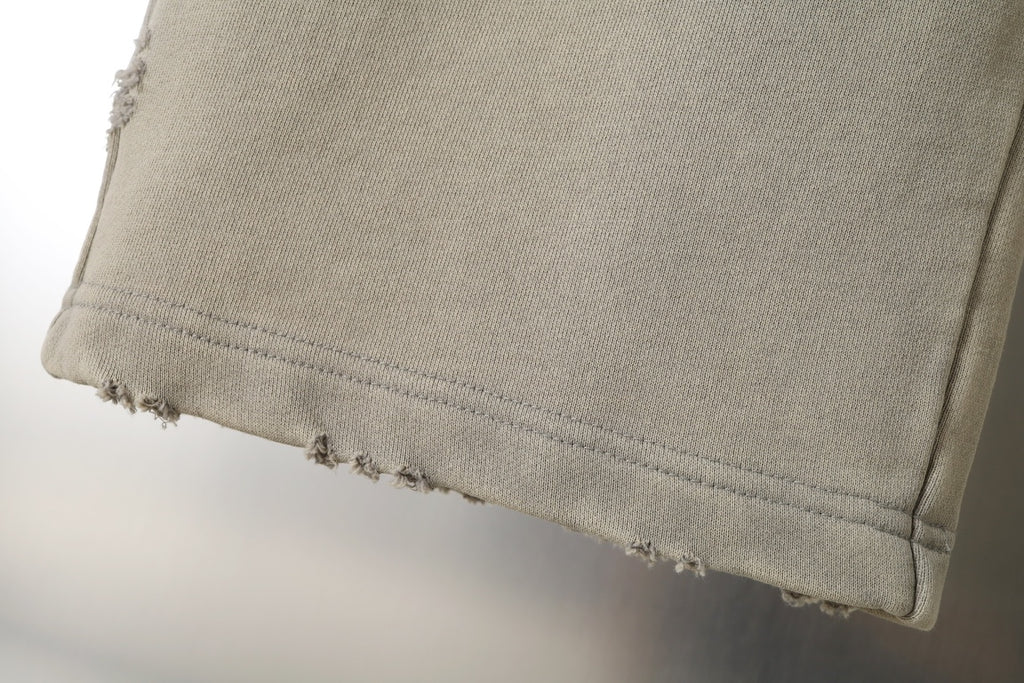 Beige pants hem with stitched cuff and slight distressing