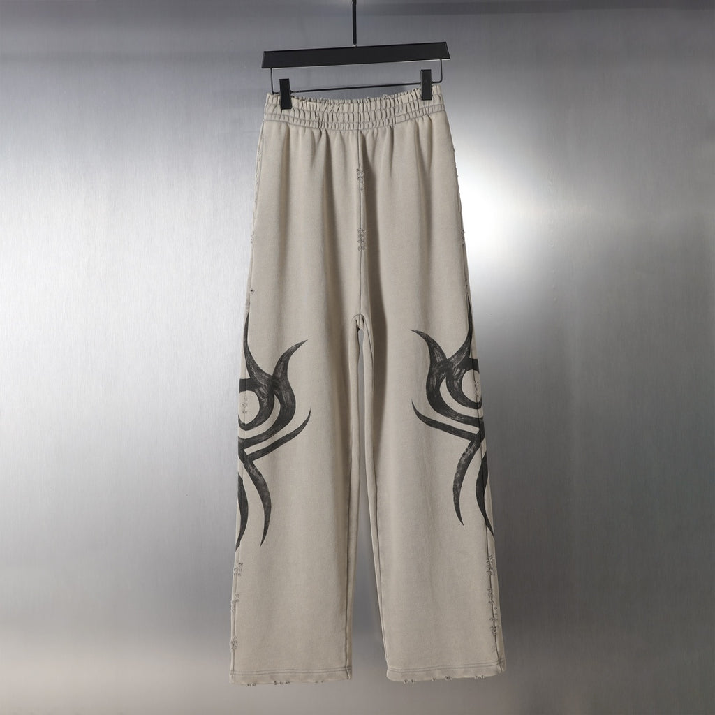 Beige drawstring pants with large black flame graphic on each leg.