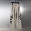 Balenciaga beige wide-leg pants with black flame graphic on both legs
