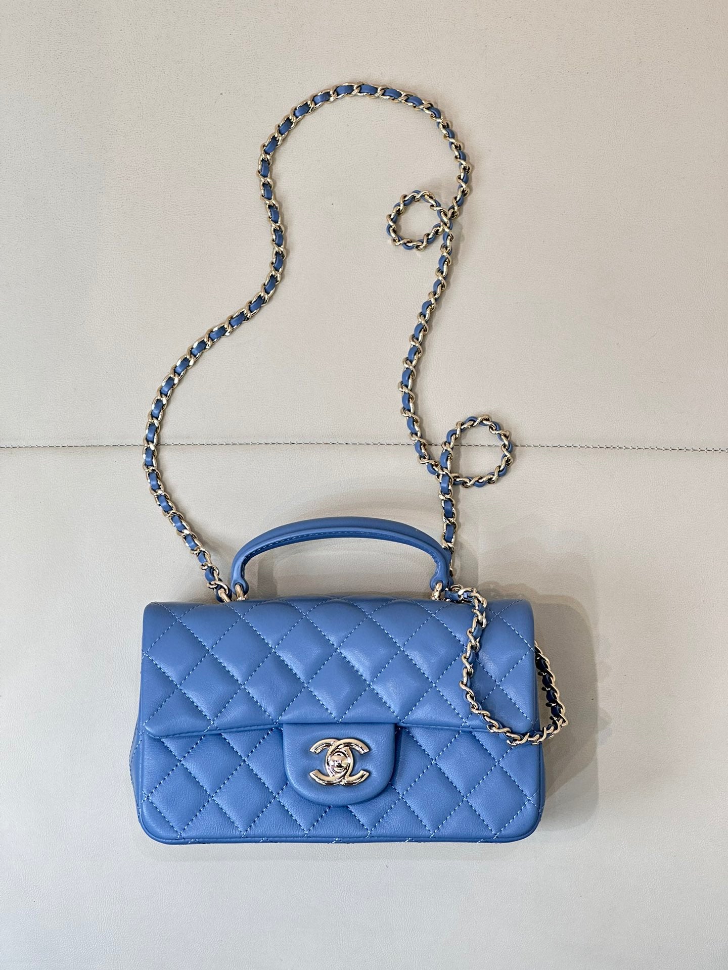 Chanel blue quilted shoulder bag with flap, gold logo, and silver chain strap