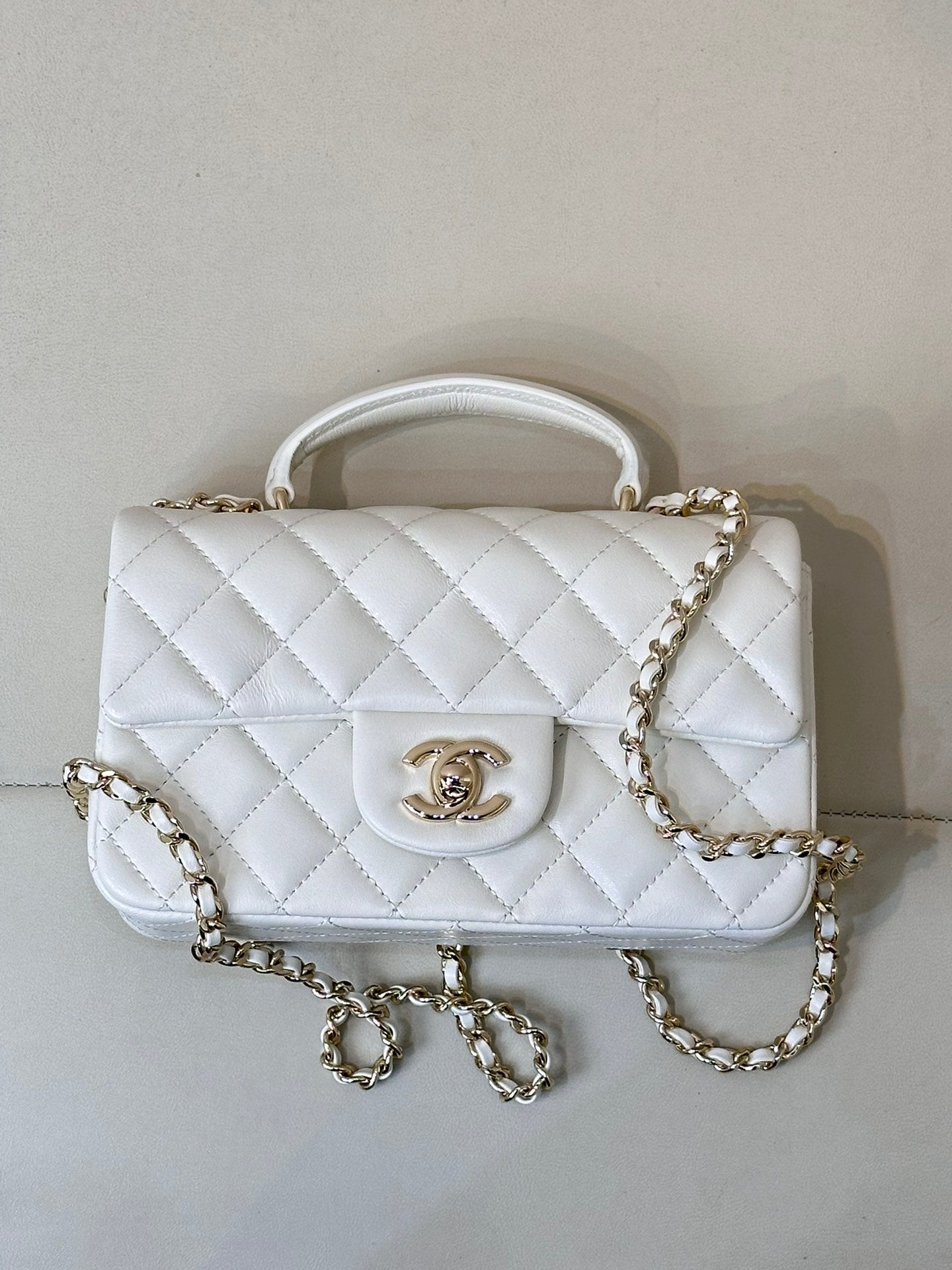 Chanel white quilted mini handbag with gold-tone chain strap and front logo medallion