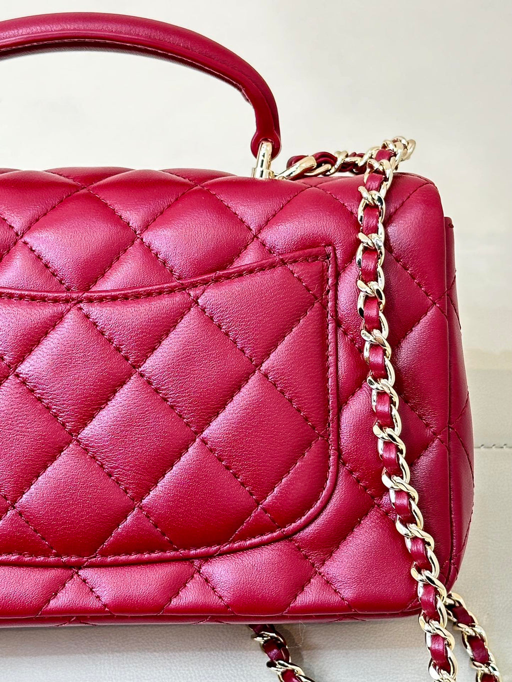Chanel quilted flap bag close-up, maroon-pink leather with chain and stitched panel