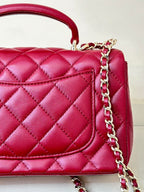 Chanel quilted flap bag close-up, maroon-pink leather with chain and stitched panel