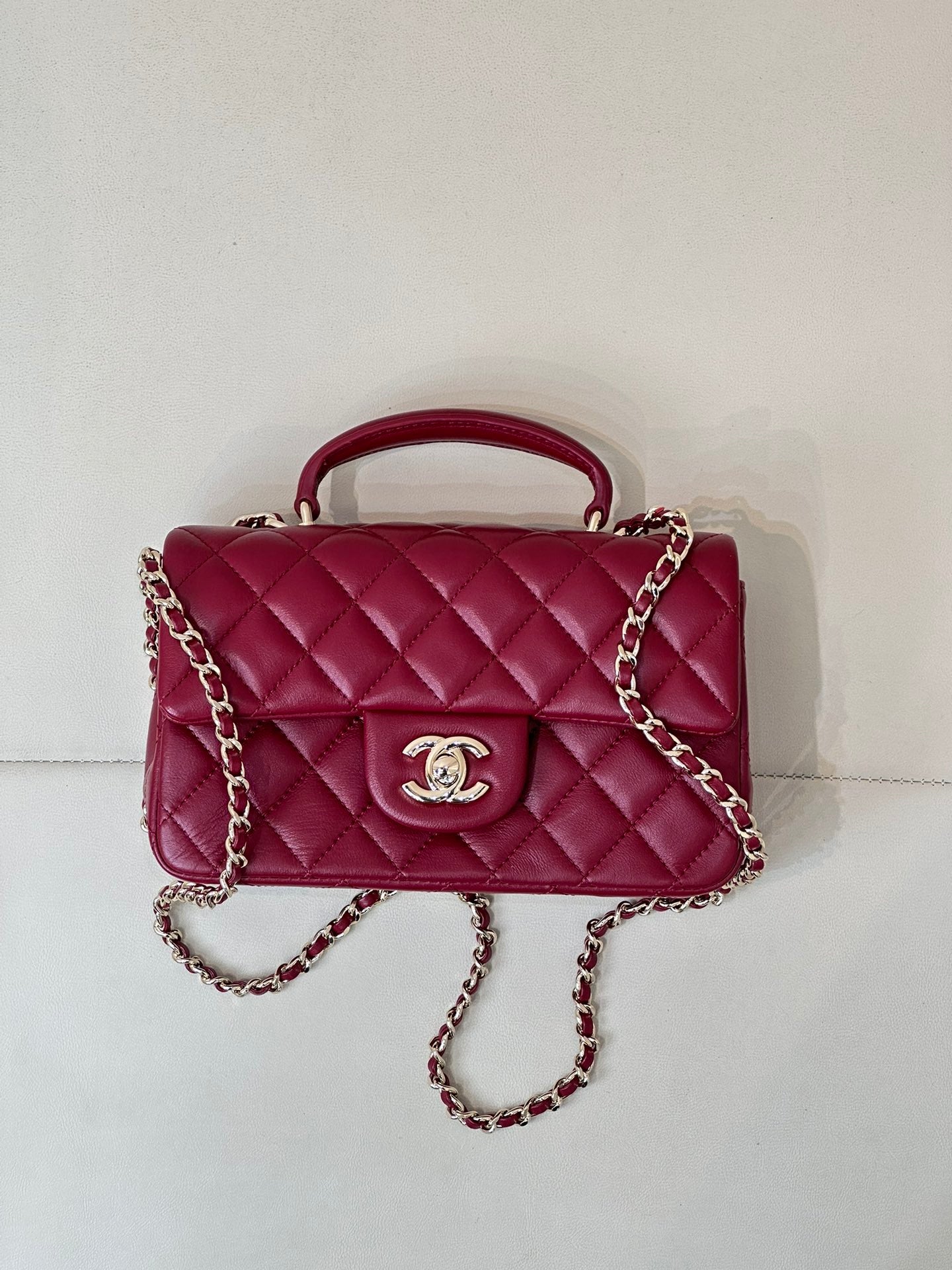 Chanel quilted flap bag with chain strap and top handle, maroon-pink leather